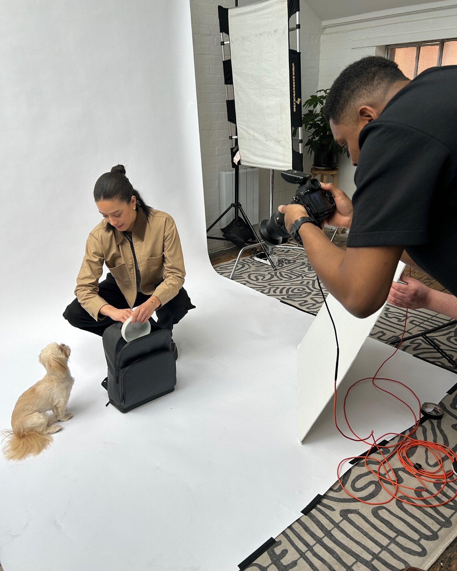 Behind the scenes of the Fetchamo Core Backpack campaign as the photographer captures the model and dog in the studio.