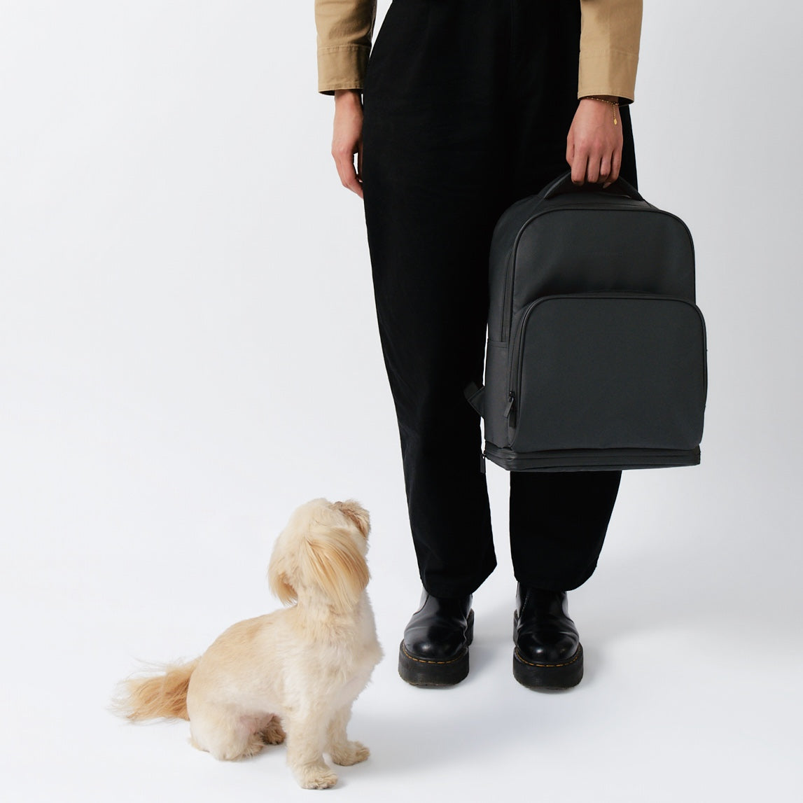 fetchamo Core backpack for dog owners – model holding the backpack with dog looking up at her