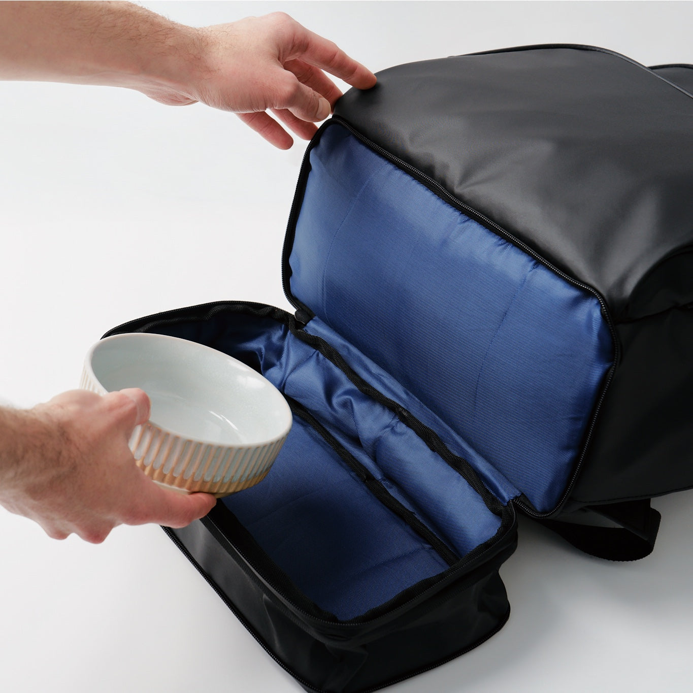 fetchamo Core backpack for dog owners – placing a dog bowl into the expandable compartment