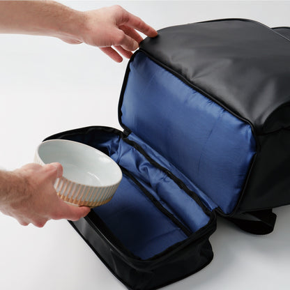 fetchamo Core backpack for dog owners – placing a dog bowl into the expandable compartment